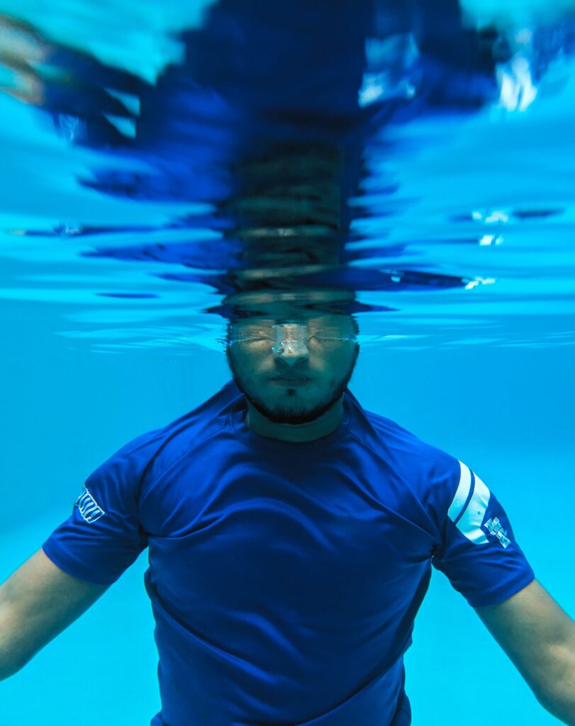 man submerged in the pool testing to find out the pool depth