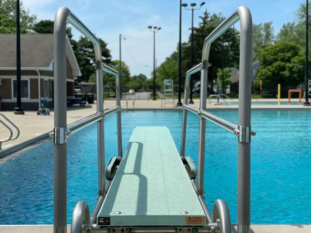 turquoise diving board for inground pool installed over a backyard pool