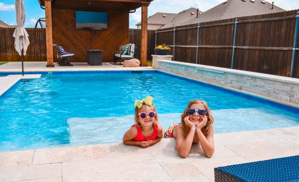 Two kids in a custom pool shortly after reopening.