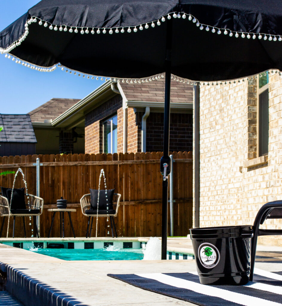 Custom plunge pool in a small backyard with fountains and umbrella.