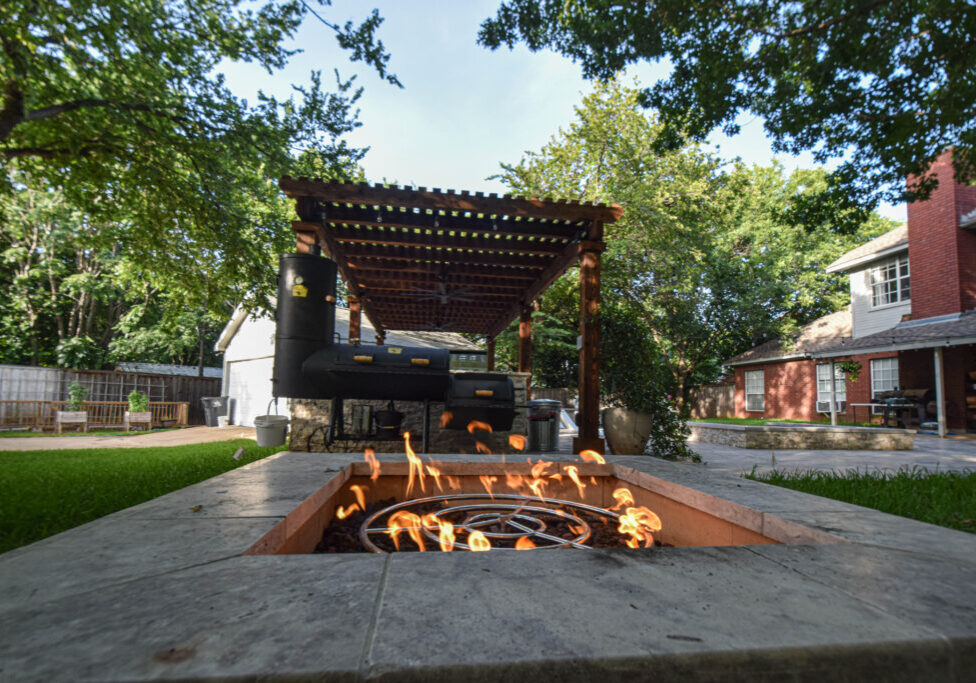 Cozy outdoor space including a sunken gas firepit.