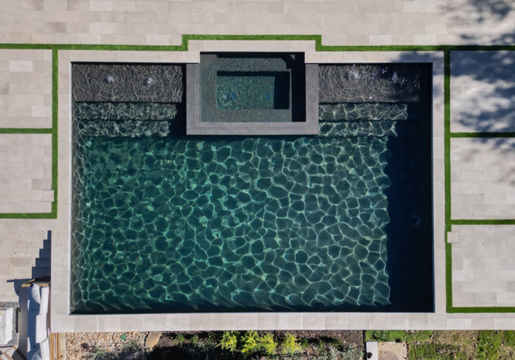 Aerial view of a custom pool with turf inlay which is one of the top design trends of 2025.