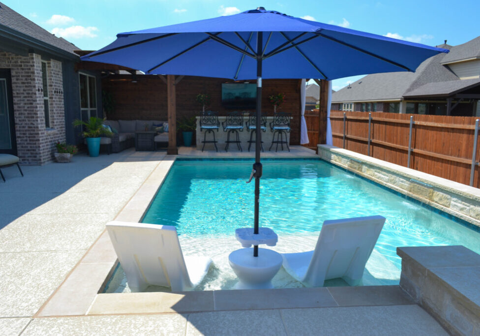 Safe, long lasting custom pool after soil injections completed with umbrella and lounge chairs.